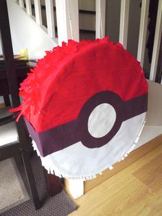 a pokeball pinata sitting on top of a wooden floor next to a stair case