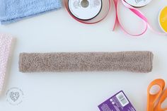 various craft supplies laid out on top of a white table with scissors, tape and other items