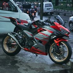 a red and black motorcycle parked on the street