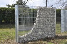 there is a rock wall in the middle of this fenced off area that looks like it's made out of rocks