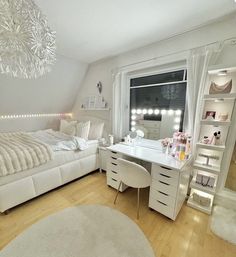 a bedroom with white furniture and a chandelier hanging from the ceiling