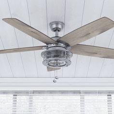 a ceiling fan is hanging from the ceiling in a room with white walls and wood planks