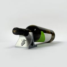 a bottle of wine sitting on top of a metal holder with a corkscrew attached to it