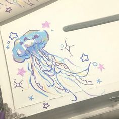 a drawing of a jellyfish on a piece of white paper with purple and blue stars