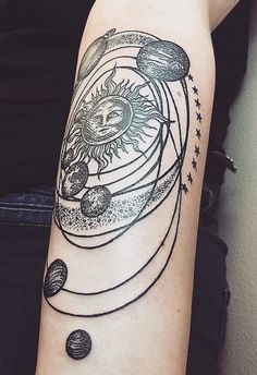 a woman's arm with a sun and planets tattoo on it