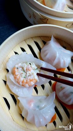 shrimp and praw dumplings with chopsticks on a bamboo tray, ready to be eaten