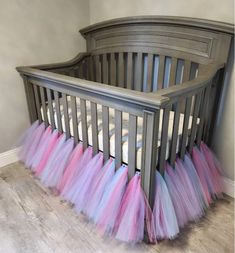 a crib with pink, blue and purple tulleries on the bottom rail