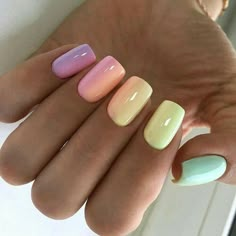 a woman's hand with four different colored nail polishes on her fingers and one is