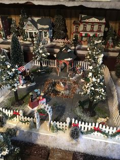 a christmas village is shown with snow on the ground and trees in the front yard