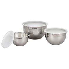 three stainless steel bowls with lids on each side and one empty bowl in the middle