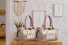 two brown bags sitting on top of a wooden table in front of a white wall