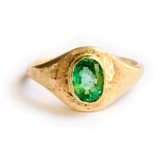 The Emerald Signet engagement ring is a truly special ring, hand formed and heavily hammered gold glittering like treasure around the bright green stone, at once opulent and organic with an ancient feel. The substantial .75 carat emerald measures 6x4mm, and is set low in a hand-formed 14k recycled yellow gold bezel. The signet profile tapers from 9mm on the topside of the ring to a slim 2mm on the underside, perfect for everyday wear. Emerald Signet | Emerald Signet Engagement Ring Hammered 14k Timeless Green Round Band Jewelry, Green 14k Gold Signet Ring With Bezel Setting, Oval Green Signet Ring For Wedding, Fine Jewelry Green Signet Ring With Birthstone, Green Oval Signet Ring For Wedding, Heirloom Oval Green Emerald Ring, Green Bezel Set Signet Ring For Wedding, Green Signet Ring With Bezel Setting For Wedding, Green 14k Stamped Signet Ring