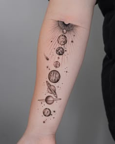 a woman's arm with planets and sun on it