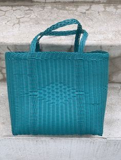 a blue wicker bag sitting on the steps