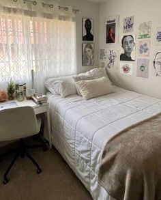 a bed sitting in a bedroom next to a white desk and window with pictures on the wall