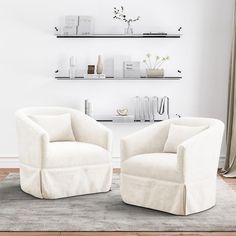 two white chairs sitting next to each other on top of a rug