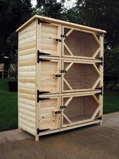 a large wooden cabinet sitting on the side of a road in front of some grass