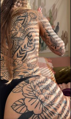 a woman with tattoos on her back and arms