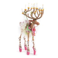 a doll is dressed up as a deer with shoes on it's feet and holding a candelabra