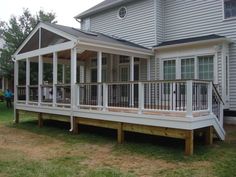 a porch with white railings on the side of a house