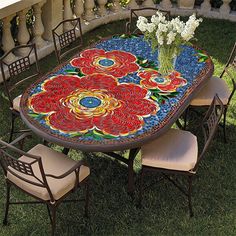 an outdoor table with flowers painted on it