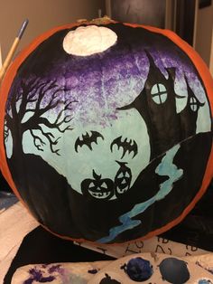 a pumpkin decorated to look like a tree with bats on it