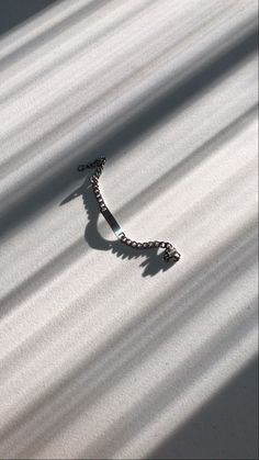 a chain is attached to the side of a snow covered roof with sunlight shining on it