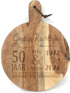 a wooden cutting board with the date and year printed on it, hanging from a hook