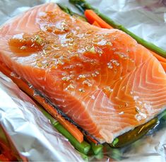 salmon, asparagus and carrots on tinfoil with seasoning in them