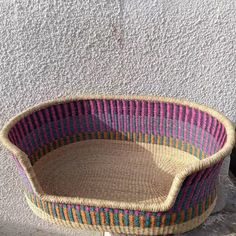 a basket sitting on the ground next to a wall