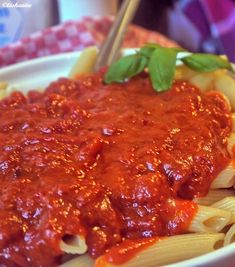 a plate of pasta with sauce on top