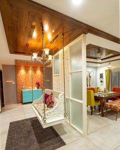 a living room filled with furniture next to a dining room table and chairs on top of a rug