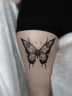 a woman's thigh with a butterfly tattoo on her left side ribcage