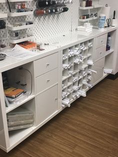 there is a large white counter with many items on it and shelves above the counter