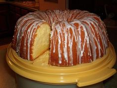 a bundt cake sitting on top of a yellow platter covered in icing