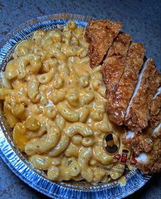 a plate filled with macaroni and cheese next to fried chicken