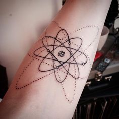 a black and white tattoo on the arm of a person with an object in it's center