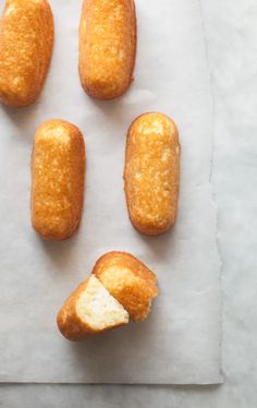 four doughnut holes are shown on a piece of parchment paper with one half eaten