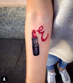 a woman's arm with a lipstick tattoo on it