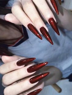 a woman's hands with long red nails