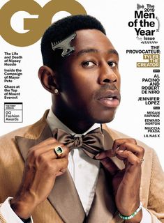 a man in a tuxedo adjusts his bow tie on the cover of gq magazine