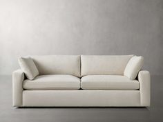 a white couch sitting on top of a gray floor