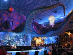 an aquarium filled with lots of people sitting at tables