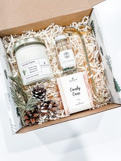 an open gift box containing candles, soaps and pine cones