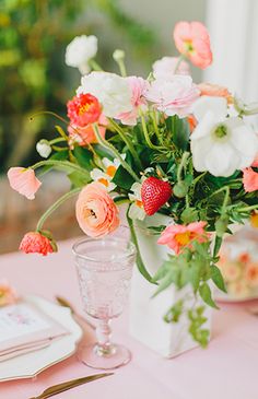 a vase filled with flowers sitting on top of a table next to plates and utensils