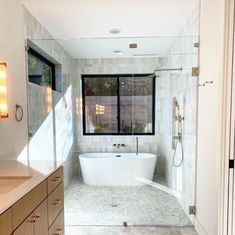 a bathroom with a tub, sink and large window in it's center area