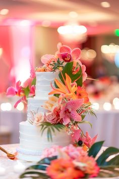 a white wedding cake with pink and orange flowers