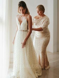 two women standing next to each other in dresses and one is wearing a dress with sequins on it