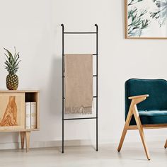 a blue chair sitting next to a wooden shelf with a pineapple plant on it