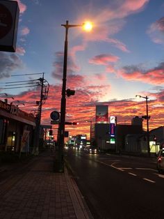 the sun is setting over a city street